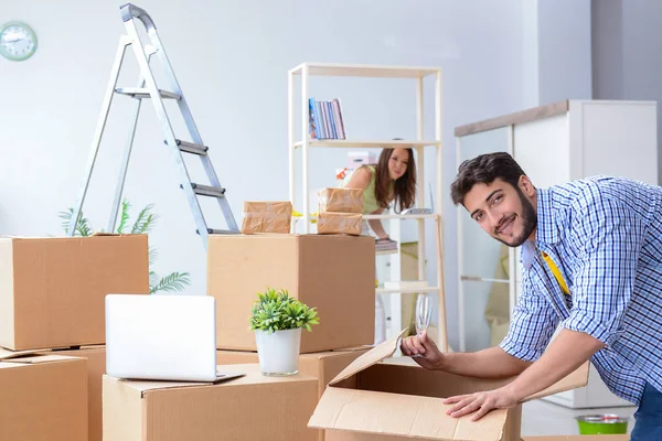 Familia joven desempacando en casa nueva con cajas —  Fotos de Stock