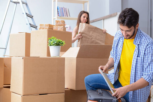 Молодая семья распаковывает в новом доме коробки