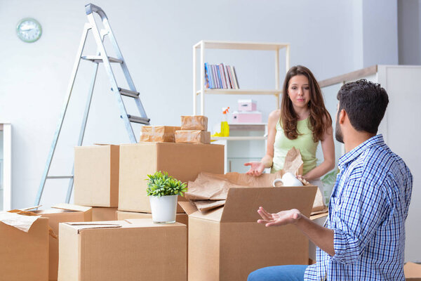 Молодая семья распаковывает в новом доме коробки