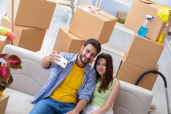 Familia joven desempacando en casa nueva con cajas —  Fotos de Stock