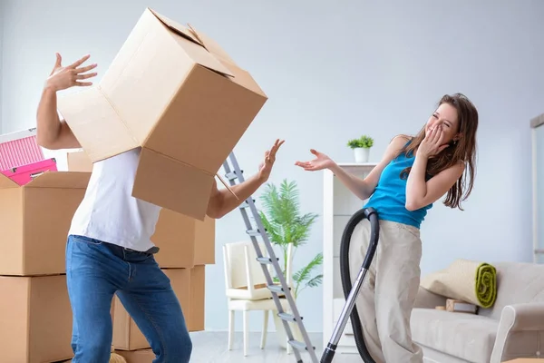 Jonge familie uitpakken bij nieuw huis met dozen — Stockfoto