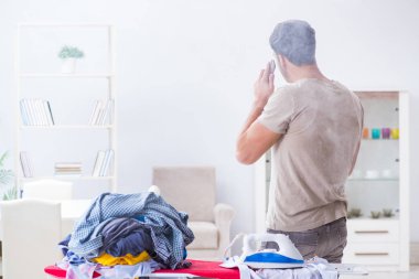 Dikkatsiz koca ütü yaparken giysilerini yakıyor.