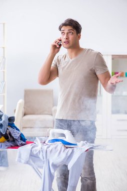 Dikkatsiz koca ütü yaparken giysilerini yakıyor.