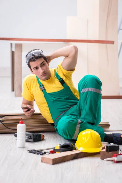 Empreiteiro que trabalha no piso de madeira laminado — Fotografia de Stock