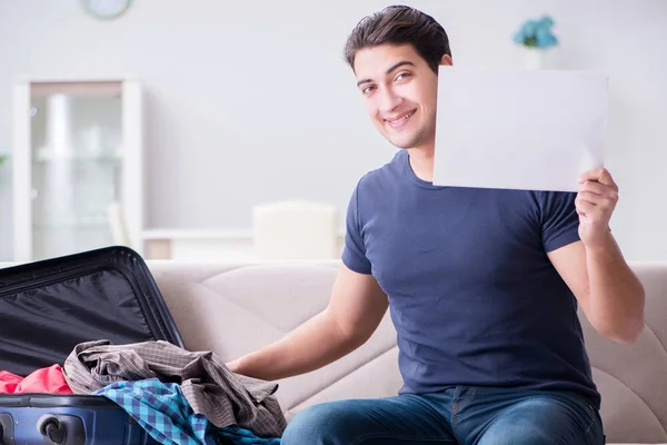 Ung man förbereder packning för sommarsemester — Stockfoto