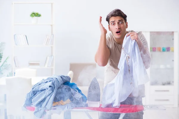 Unaufmerksamer Ehemann verbrennt Kleidung beim Bügeln — Stockfoto