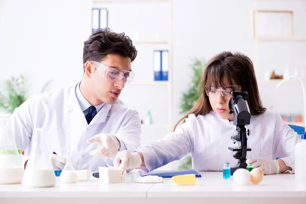 Dois médicos de laboratório testando produtos alimentares — Fotografia de Stock