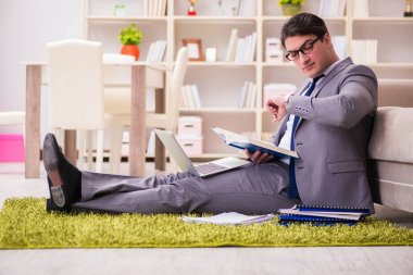 İş adamı evde yerde çalışıyor.