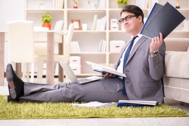 İş adamı evde yerde çalışıyor.