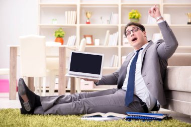İş adamı evde yerde çalışıyor.