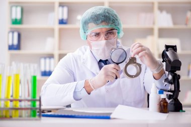 Criminologist police chemist looking at crime evidence clipart
