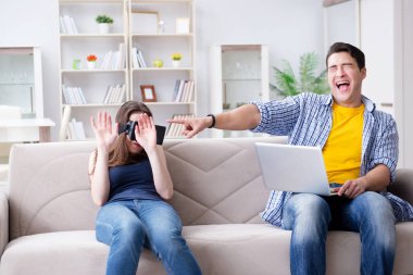 Genç bir aile sanal gerçeklik gözlükleriyle oyun oynuyor.