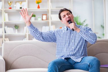 Evde karaoke yapan komik adam.