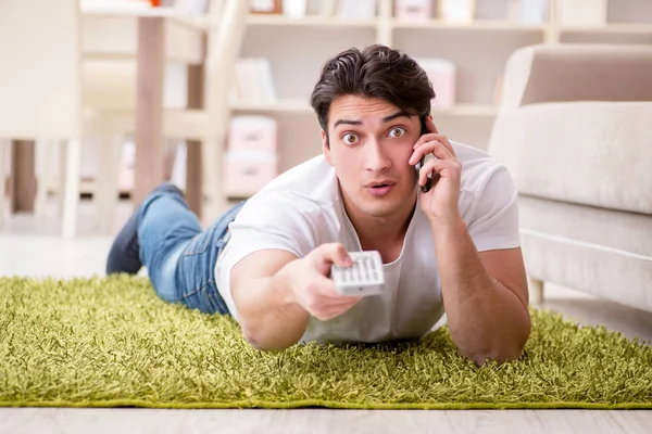 Hombre viendo la televisión en casa en el suelo —  Fotos de Stock