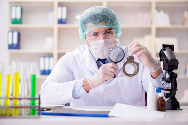 Criminologist police chemist looking at crime evidence