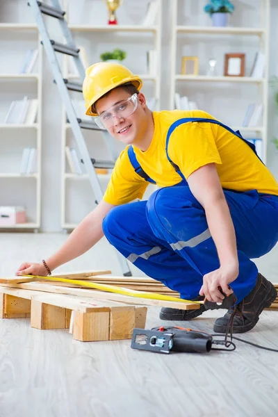 Jeune homme assemblant des palettes en bois — Photo