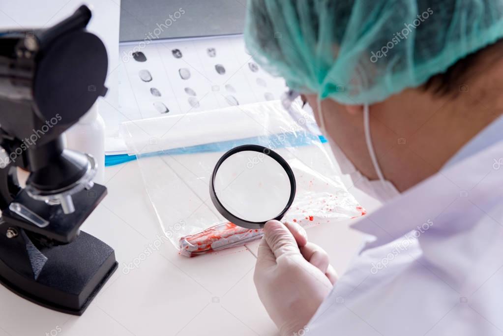 Criminologist police chemist looking at crime evidence