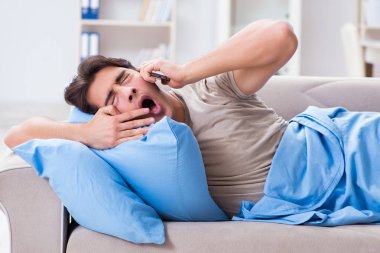 Yatakta cep telefonuna bağımlı bir adam.