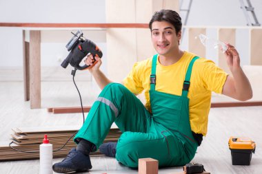 Müteahhit lamine ahşap zemin üzerinde çalışıyor.