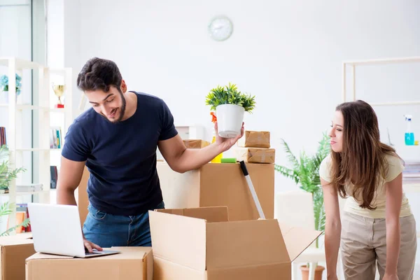 Jonge familie uitpakken bij nieuw huis met dozen — Stockfoto