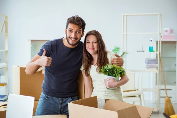 Jonge familie uitpakken bij nieuw huis met dozen — Stockfoto