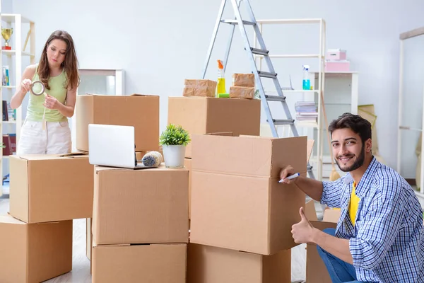 Junge Familie packt im neuen Haus mit Kartons aus — Stockfoto