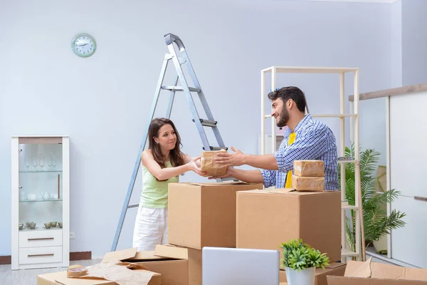Fiatal család kipakol az új házban dobozokkal — Stock Fotó