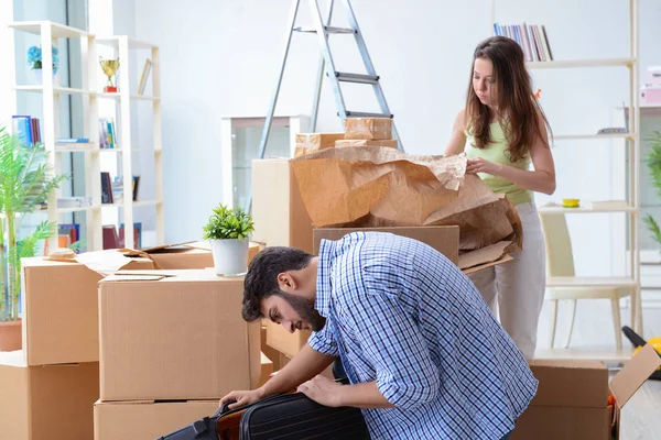 Familia joven desempacando en casa nueva con cajas — Foto de Stock