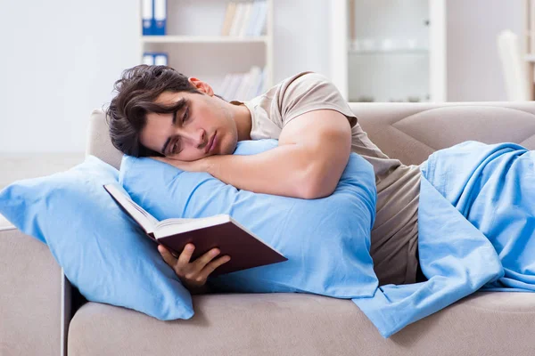 Üniversite sınavlarına hazırlanan genç bir öğrenci kitapla yatakta. — Stok fotoğraf