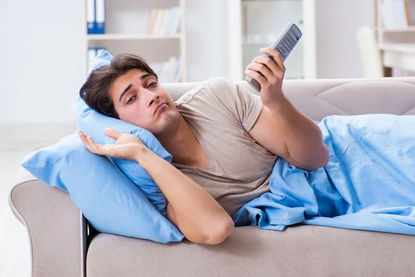 Man watching tv from bed holding remote control unit — Stock Photo, Image