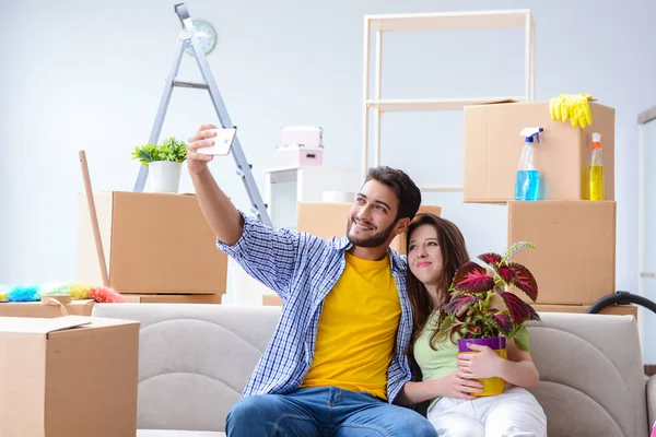 Familia joven desempacando en casa nueva con cajas — Foto de Stock