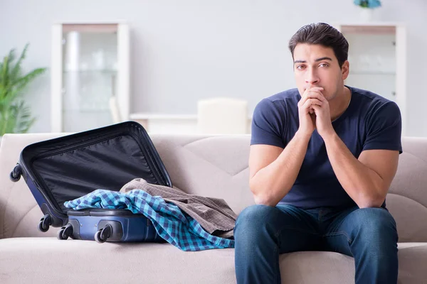 Young man preparing packing for summer vacation — Stock Photo, Image