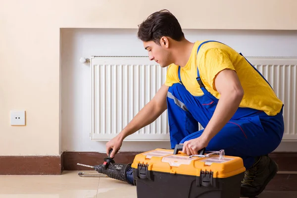 Young repairman contractor repairing heating panel — Stock Photo, Image