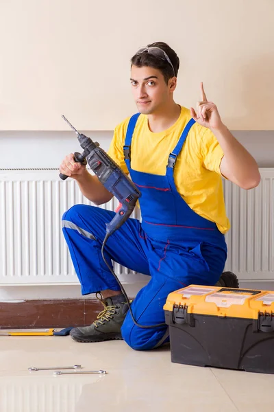 Jovem reparador contratante reparação painel de aquecimento — Fotografia de Stock