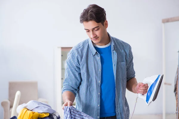 Jeune homme mari faire du repassage des vêtements à la maison — Photo