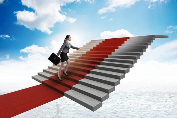 Молодая предпринимательница поднимается по лестнице и красной дорожке — стоковое фото