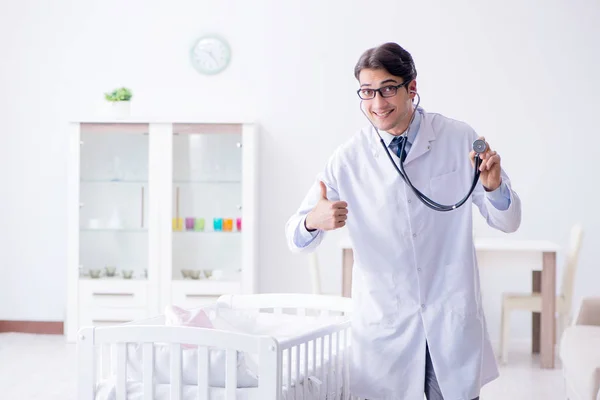 Erkek çocuk doktoru bebek yatağının yanında muayene etmeye hazırlanıyor. — Stok fotoğraf
