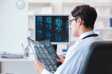 Doktor radyoloji uzmanı röntgen görüntülerine bakıyor.