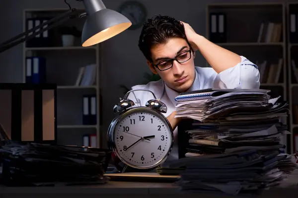 Joven hombre de negocios trabajando horas extras hasta tarde en el cargo — Foto de Stock