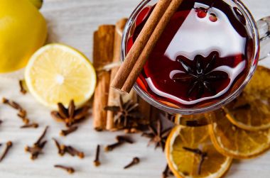 Haşlanmış şarap, yılbaşı masasında servis edilen bardaklarda parlıyor.