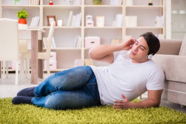 Evde müzik dinleyen genç bir öğrenci.