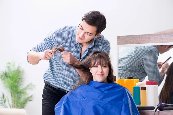 Man male hairdresser doing haircut for woman