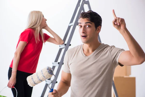 Família jovem fazendo trabalho de pintura durante a renovação da casa — Fotografia de Stock