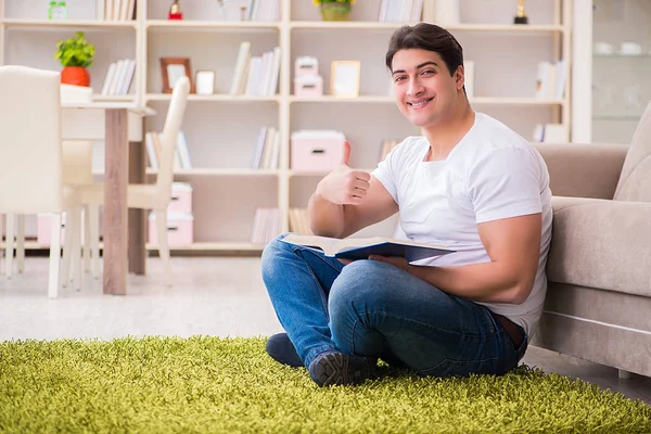 Homem lendo livro em casa no chão — Fotografia de Stock