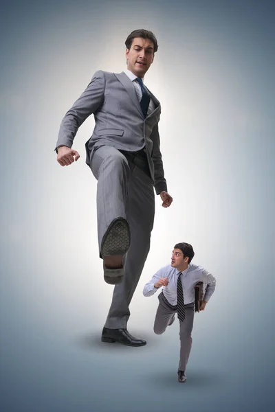 Bad angry boss kicking employee in business concept — Stock Photo, Image