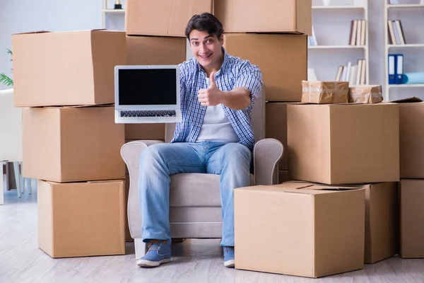 Young man moving in to new house with boxes — Stock Photo, Image