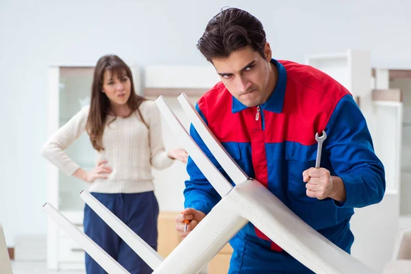 Reparador de contratistas ensamblando muebles bajo supervisión femenina —  Fotos de Stock