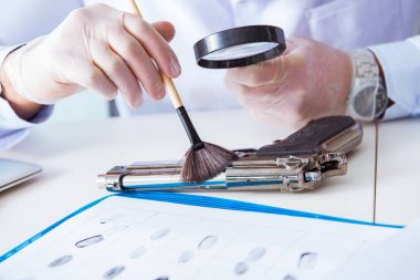 Kriminolog polis kimyageri suç delillerine bakıyor.