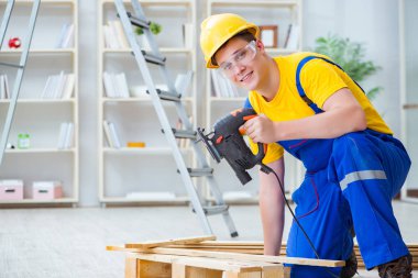 Ahşap palet montajı yapan genç adam.