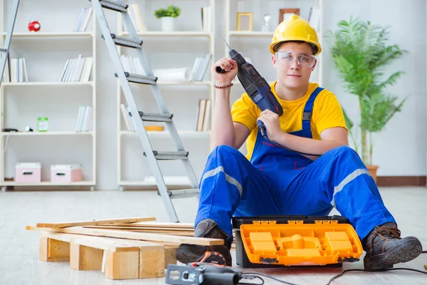 Jeune homme assemblant des palettes en bois — Photo